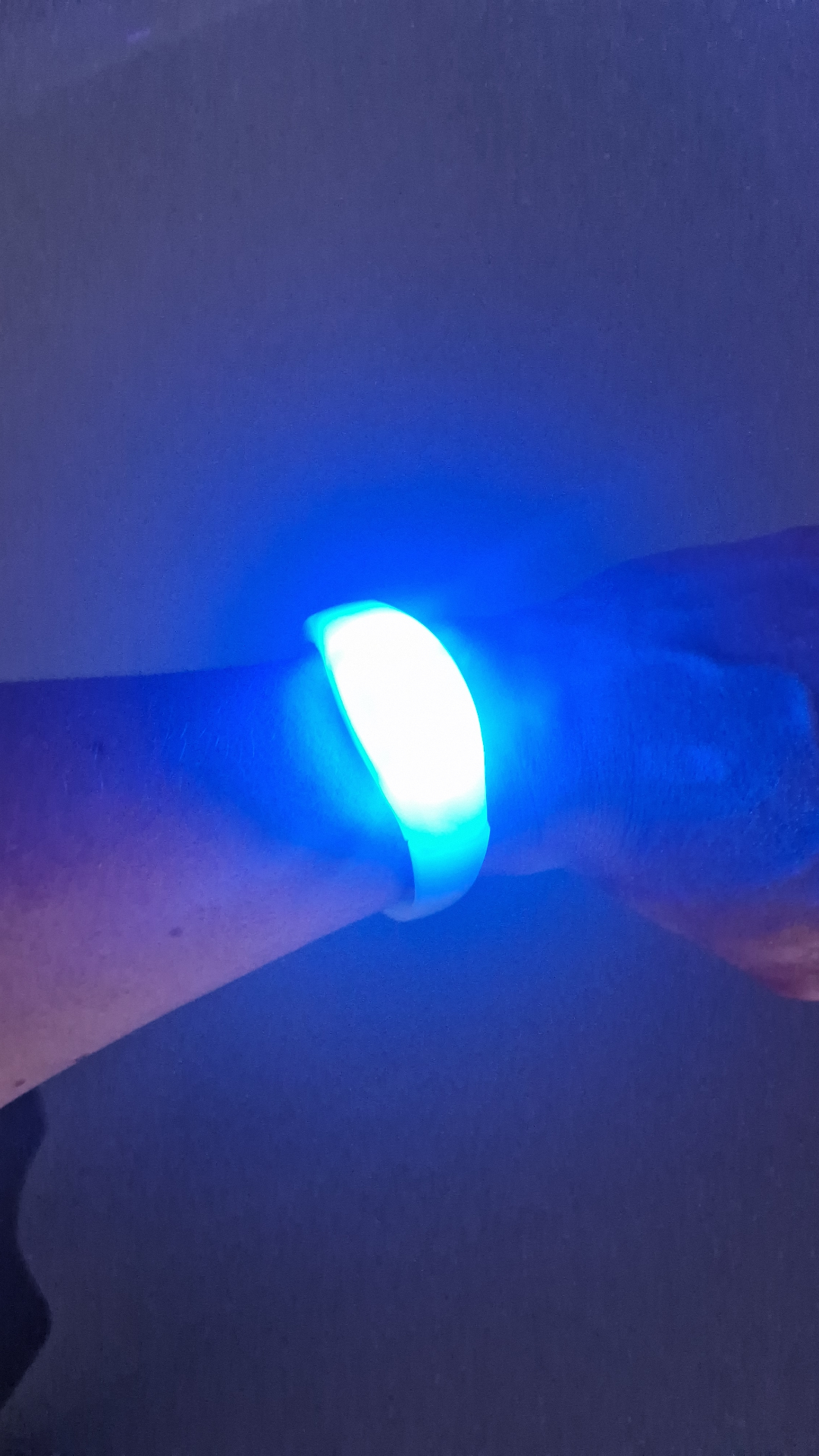 Glowing wristband on a wrist in a nightclub